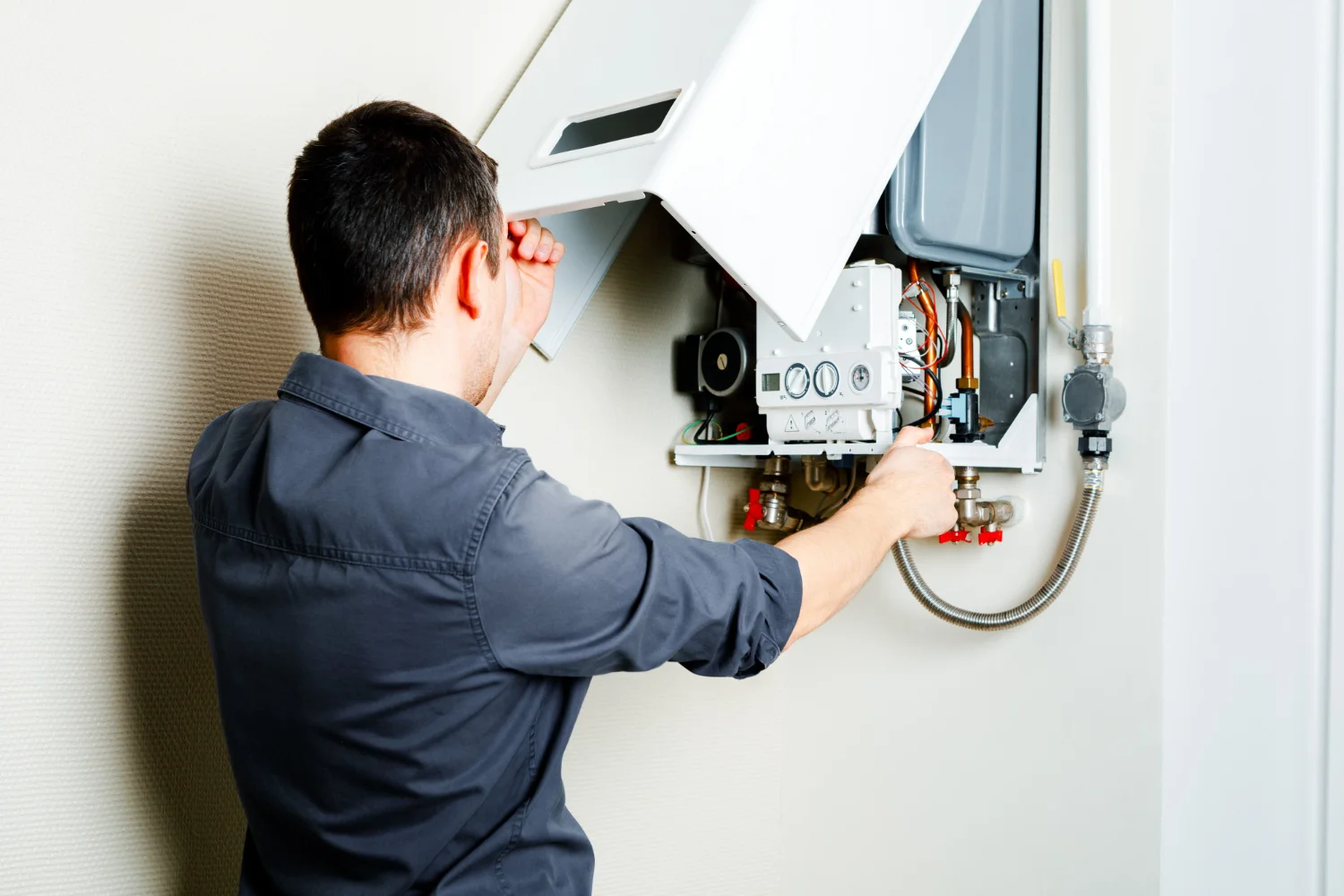 Engineer repairing wall-mounted gas boiler