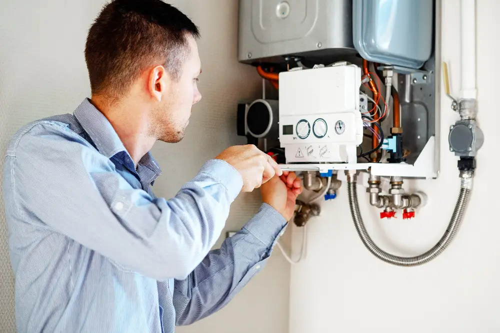 Man repairing wall-mounted home boiler unit