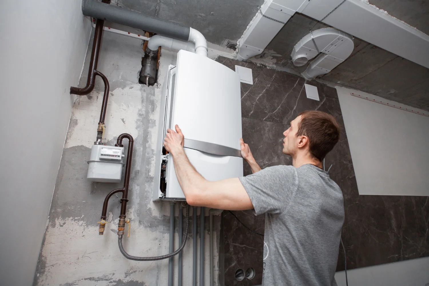 Man installing wall-mounted gas boiler