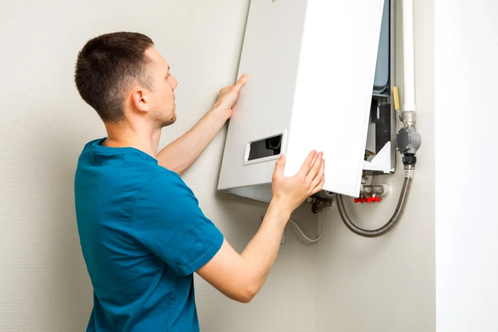 Man installing wall-mounted boiler at home