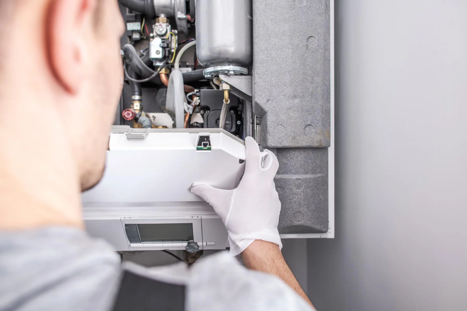 Engineer servicing a domestic boiler control panel