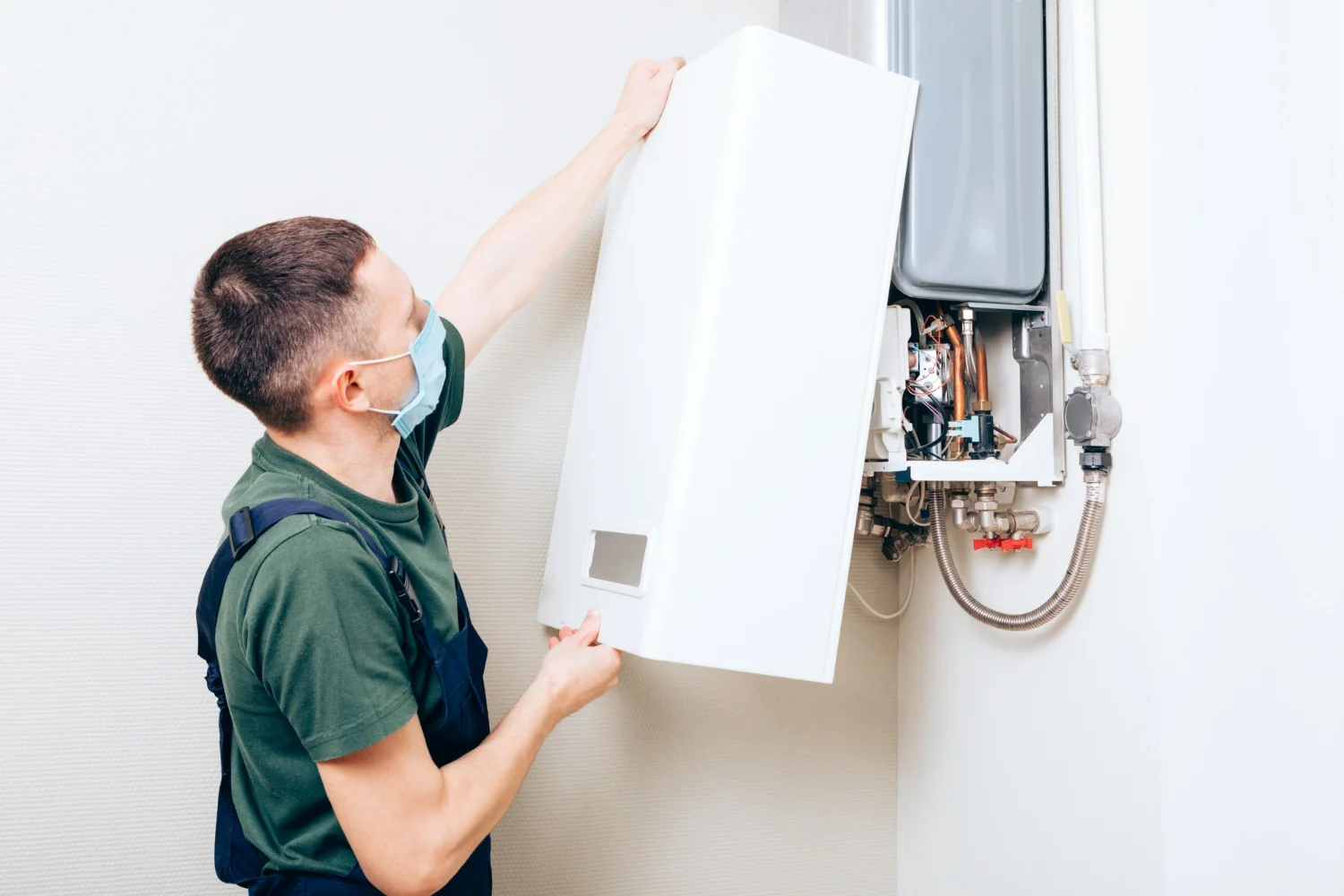 Engineer servicing wall-mounted gas boiler
