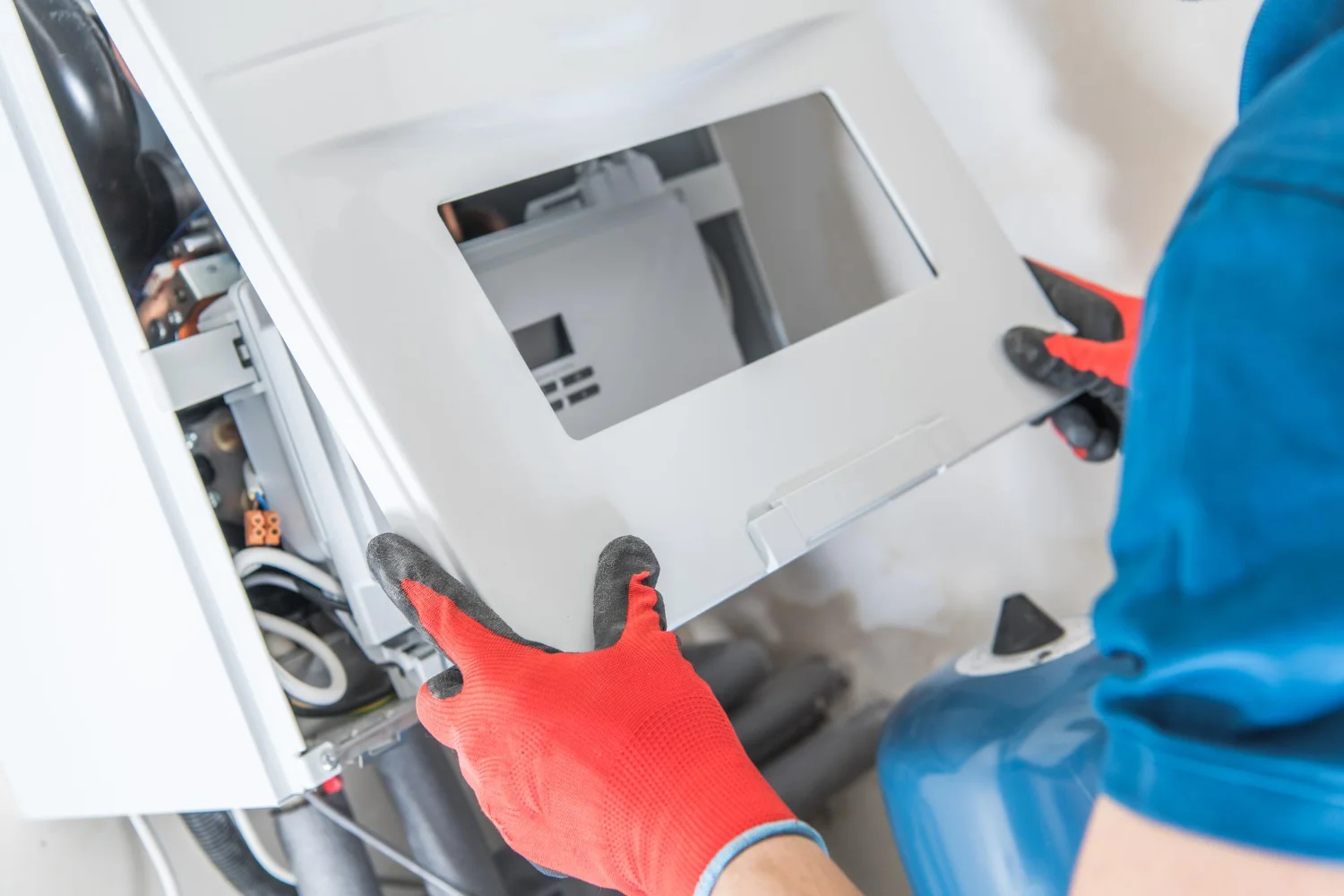 Technician installing boiler front panel