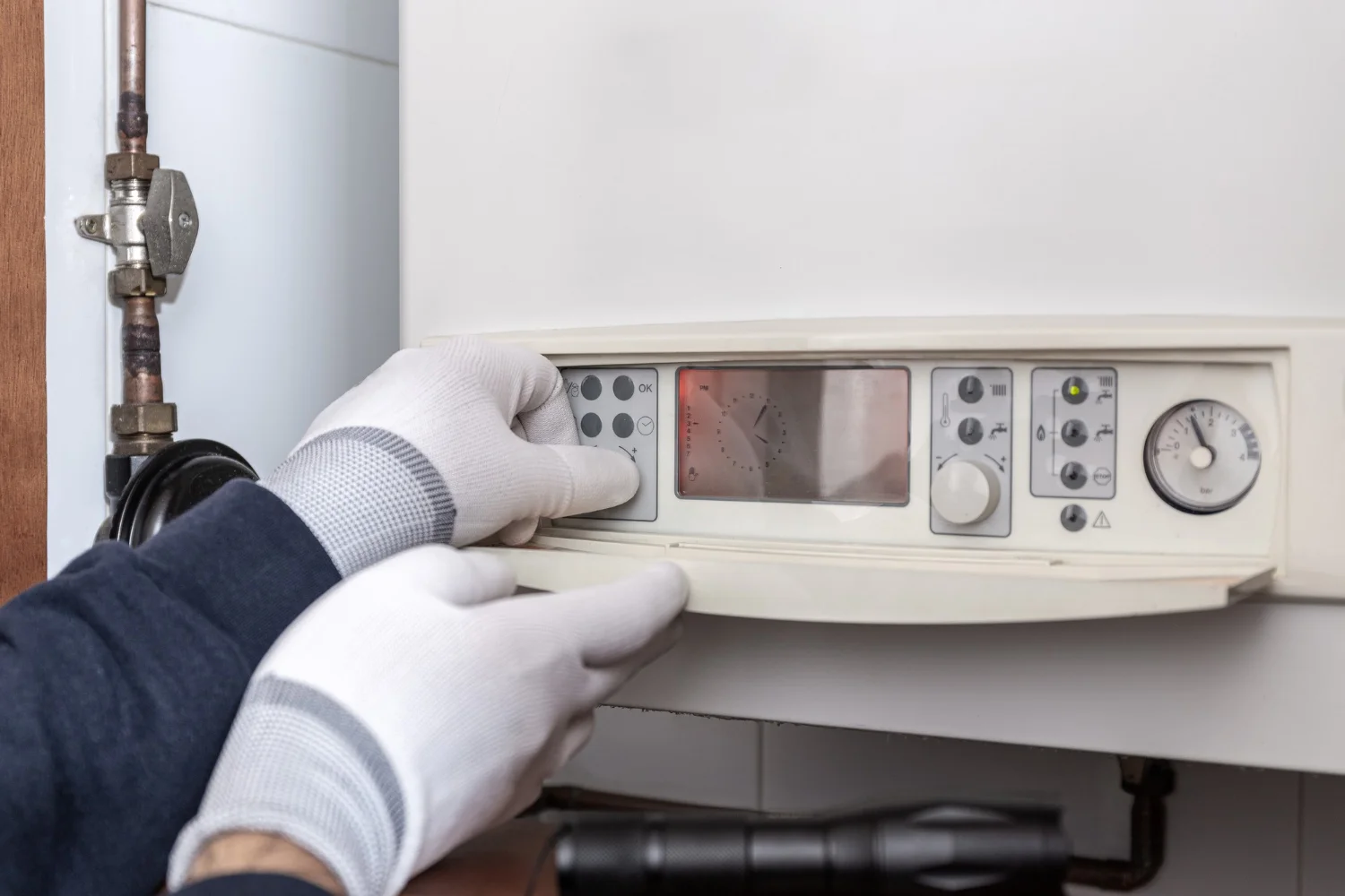 Technician adjusting domestic boiler control panel