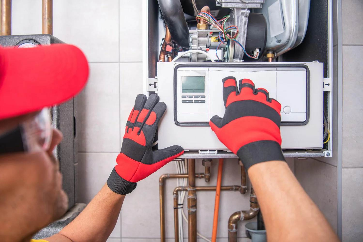 Technician adjusting domestic boiler control panel