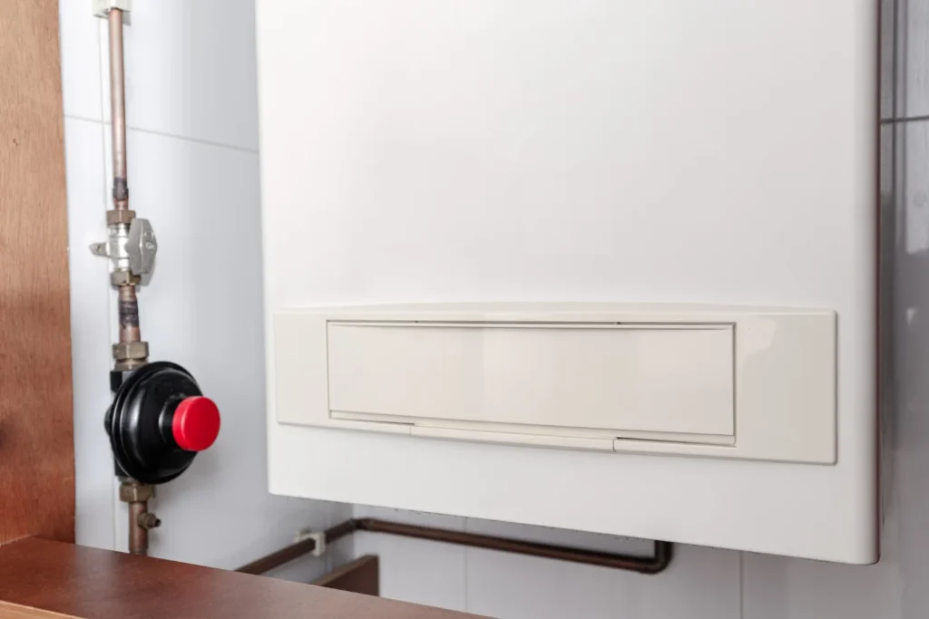 Wall-mounted boiler beside copper gas pipe and shut-off valve